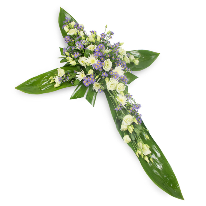 Against an uncluttered white backdrop and photographed from a modest overhead angle, this floral cross presents a marriage of strong foliage and delicate blooms: broad, gleaming green leaves create the armature of the cross, their waxy texture and visible veins anchoring the form with a deep, living green. Crowning the centre and trailing gently along each arm are clusters of cream and pure-white lisianthus, their ruffled edges and soft layering offering an almost fabric-like tenderness. Intermixed are small, daisy-like white chrysanthemums that provide compact texture and points of luminous white, while airy sprays of pale purple limonium or tiny asters float through the arrangement, giving the piece a measured contrast and a whisper of cool colour. Slender filler greens are threaded between blooms to soften transitions and add an understated depth. The composition is lit with even, soft light that accentuates the contrast between the glossy leaves and the matte, petaled blooms, creating a serene, almost reverent atmosphere. Crafted with sympathy and care, this cross is suited to funeral services, memorials, or church tributes in the Mill Hill area-delivered with sensitivity to chapels and family homes near Bittacy Hill and local cemeteries-conveying compassion, peace, and a gentle celebration of memory.