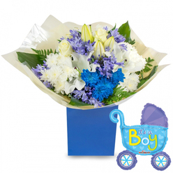 Bathed in soft studio light, this baby-boy gift set is a study in cool, comforting tones-assembled with the careful hand of an experienced florist in Mill Hill. The bouquet sits proudly in a sturdy royal-blue rectangular gift box, its matte surface grounding an airy composition of white and blue blooms. At the heart, elegant white roses nestle against partially opened white lilies, their long stamens hinting at gentle fragrance; fluffy white chrysanthemums add volume and a classic, serene base. Vibrant electric-blue chrysanthemums create a bold focal point, threaded through with clusters of pale lavender, hyacinth-like flowers that bring a delicate scent and textured silhouette. Fresh green foliage-broad, glossy leaves and feathery ferns-breathes life into the arrangement, while crinkled cream tissue wraps the stems in a tactile, gift-ready finish. To the right, a light-blue foil pram-shaped balloon floats with a soft sheen, detailed in darker-blue accents, tiny polka dots and heart shapes on its wheels, and the jubilant wording "It's a Boy" in sunny yellow and lime-green across the carriage.

Prepared by Flowers Mill Hill for welcoming ceremonies or baby showers, this ensemble balances celebration with tenderness. Imagine untying the paper to release a soft, green floral perfume, or carrying the compact box along Bittacy Hill for a hospital visit; the design is both portable and elegant. The visual rhythm of white, lavender, and electric blue feels joyful yet composed-a message of congratulations, intimacy, and careful craftsmanship for a newborn son throughout the Mill Hill area.