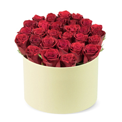 There's something poetic about this arrangement-a gathered cluster of lush scarlet roses, each blossom at its peak, the petals firm and supple, their crimson glow almost luminescent. They are set in a champagne-hued round hatbox, the box's soft matte surface providing a restrained counterpart to the vibrant blooms. The roses form a flawless, gently domed composition inside the cylindrical container; the heads crest the rim just so, creating a sculptural silhouette. A whisper of dark green foliage threads between the flowers, lending depth and a touch of woodland freshness. The light is soft and diffuse, caressing the petals to reveal their velvety texture; the scent of rose is present, a romantic invitation. The whole display sits against a plain white backdrop, letting the craft of the arrangement speak. This bouquet is the quintessential romance gift, ideal for milestones, anniversaries, or simply to express deep admiration. Hand-placed by a seasoned local florist, it speaks of skill, patience, and love for the craft. In Mill Hill, this beauty is available for same-day delivery to nearby streets such as Daws Lane, Mill Hill Broadway, and the surrounding neighbourhoods, reinforcing the sense of thoughtful gifting that arrives just when it is needed.
