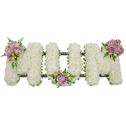 This striking sympathy tribute spells 'MUM' in substantial, free-standing letters completely covered in densely packed white spray chrysanthemums, each petal overlapping to form a cloud-like, textured surface that reads both tender and immaculate. The arrangement is punctuated with three modest clusters of pastel roses - muted lavender blooms and small pink buds - placed with deliberate symmetry on the upper left of the first 'M', within the curve of the 'U', and on the upper right of the last 'M'. These roses, velvet to the eye, add a whisper of warmth amid the expansive white, while fern fronds and lighter green foliage curl and frame each cluster to provide depth and a natural, composed rhythm. Beneath the flowers a dark green supporting structure - possibly moss-wrapped foam or ribboned floral board - gives the letters a defined silhouette and ensures they stand with quiet strength.

Seen in the soft light of a chapel or community hall near Mill Hill Broadway, the tribute conveys a feeling of gentle reverence and calm acceptance. The tactile contrast between fluffy chrysanthemums and velvety rose petals creates a comforting visual and a faint, clean floral scent. Prepared with attention to balance and proportion, this classic memorial piece is suitable for a funeral service, wake, or graveside dedication, offering a heartfelt symbol of respect and lasting remembrance for a mother cherished by family and friends across the Mill Hill area.