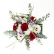 There is a festive elegance in this bouquet, as seen from above-a true reflection of Mill Hill's tranquil leafy lanes and close-knit community. Deep, velvety red roses create an inviting focal point at the heart of the arrangement, their passionate hue softened by creamy white gerbera daisies with striking brown centers. Cushions of delicate white spray chrysanthemums surround these central blooms, offering a gentle, airy texture that calls to mind soft clouds above Mill Hill's open spaces. A scattering of lilac-tinted Lisianthus is gracefully tucked in, whispering notes of serene purple that provide a soothing contrast to the bolder colours. Encircling all, abundant silvery-green eucalyptus leaves arch outward, their rounded forms adding both freshness and a gentle, aromatic touch suggestive of walking through Mill Hill Park on a clear, early morning. Wisps of slender green foliage peek out, giving the arrangement subtle depth and a relaxed, yet curated, sense of movement. The crisp lighting highlights each blossom's texture and hue, making the bouquet feel as vivid and fresh as if just gathered by hand from a Mill Hill florist. Perfect as a centrepiece for family gatherings, winter get-togethers, or heartfelt celebrations, this bouquet radiates warmth and sophistication, infusing any setting with the enduring beauty of Mill Hill's blooming spirit.
