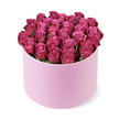 A carefully styled hat box arrangement of deep pink roses is captured in crisp detail against a stark white background, creating a contemporary yet romantic look that would feel at home in any Mill Hill interior. The box is round and upright, coloured a gentle, light pastel pink with a soft, velvety matte finish that looks smooth and almost suede-like. Overflowing from the top, dozens of roses are arranged into a perfect dome, their heads touching in a tight, seamless cluster that suggests abundance and careful craftsmanship. Each rose displays a rich fuchsia-magenta hue, with slight variations where the light touches the petals: softer, rosy-pink tones at the heart of each bloom deepen into more dramatic berry shades along the outer curls. The petals themselves appear thick and velvety, their edges gently ruffled and layered in concentric spirals that invite the eye to linger on their detail. Almost no greenery is visible, emphasising the monochromatic intensity of the flowers and the deliberate, minimalist design of the piece. A gentle, even light illuminates the arrangement, throwing only a faint shadow beneath the box that anchors it against the white surface without competing for attention. Viewed from a slightly elevated angle, the roses form a sumptuous, cushion-like crown, as if ready to be placed at the centre of a dining table overlooking Mill Hill's green spaces. This arrangement suggests a generous, heartfelt gesture-perfect for anniversaries, Valentine's surprises, or milestone celebrations-delivered by Flowers Mill Hill to homes near Mill Hill Broadway, along Daws Lane, or in the quieter residential roads stretching up towards Mill Hill Village.