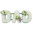 The photograph shows a personalised DAD funeral tribute, created with the kind of care and precision associated with local Mill Hill floristry. Three large, upright letters form the word, each one completely covered in tightly packed white chrysanthemums. The small, rounded blooms are arranged so closely that they create a continuous, cushion-like surface, with no stems or gaps visible. The petals, slightly ruffled and luminous against the white background, soften the strong shapes of the letters and evoke a sense of peace and purity. Around the edges of all three letters, a deep emerald green ribbon has been carefully pleated and fixed in place, tracing every curve and corner. This ruffled border frames the white flowers with a fresh, vibrant outline, reminiscent of the green landscapes surrounding Mill Hill. Subtle glimpses of a dark horizontal frame behind the flowers show how the letters are supported, holding them together as a single, freestanding tribute.   

The arrangement is gently accented with tasteful floral sprays. On the upper left curve of the first D, a small posy of white freesia and glossy green foliage is nestled among the chrysanthemums, the freesia buds and delicate bells introducing texture and a hint of fragrance. Two long, slender green stems then arc diagonally across towards the central A, guiding the eye and linking the letters visually. At the lower right side of the A, where the stems meet, a more dramatic focal point emerges: two deep purple calla lilies, velvety and elegantly rolled, sit among more white freesia and bright greenery. Their rich colour brings depth and formality to the tribute without overpowering the calm, white base. The final D is adorned on its upper right edge with another, slightly smaller cluster of white freesia and foliage, echoing the first letter and completing the design.   

Presented against a simple white background, the tribute feels quietly dignified and deeply personal. It is easy to imagine it being delivered by Flowers Mill Hill to a local church or crematorium, where it would stand as a clear, floral expression of love and remembrance for a father who will not be forgotten.