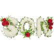 A tender, hand-shaped memorial spells out the letters SON in three bold, capital forms, each letter built from a plush carpet of small, pristine white spray chrysanthemums that read as pure and reverent at a glance. The white blooms are densely packed to create pillow-like texture and a soft, matte surface; up close you can almost sense the faint, clean scent of chrysanthemum and the cool, papery feel of each tiny petal. Rich, velvety red roses punctuate the composition, their deep crimson heads providing a dramatic, loving counterpoint against the white. On the S, a tight cluster of three red roses nestles into the upper left curve, framed by glossy dark-green leaves. The O is grounded by a single, prominent red rose placed at its lower centre, cradled by feathery fern fronds and additional mid-green foliage that give the circle a gentle focal heartbeat. The N bears a vertical trio of the same deep roses along its right side, the grouping offering balance and a quietly solemn rhythm across the piece.
Trailing ivy weaves organically through and around every letter, its satin leaves adding line, depth, and the evergreen symbolism of memory continuing on. The arrangement sits against a clean white background illuminated by soft, natural light, which highlights shadows in the chrysanthemum texture and the rose petals' velvety sheen. Presented as a personalised funeral tribute for a son, this design reads as respectful, intimate, and crafted with care - a floral statement suited to funeral services, graveside remembrances, or a wake. Locally made in Mill Hill with experienced hands, it conveys purity, passion, and lasting remembrance without a word.