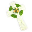 A dignified, three-dimensional Celtic cross composed entirely of fresh flowers, photographed from a slightly elevated angle against a crisp white background. The structure is built from dense clusters of pure white spray chrysanthemums whose small, feathery petals create a soft, plush surface that reads as serene and reverent. Interwoven into that white foundation are vivid apple-green button chrysanthemums, their rounded forms strategically placed to trace the circular ring at the cross's centre and to fill alternating segments along the horizontal arms, producing a classic Celtic knot suggestion and a rhythmic contrast of texture and hue. At the precise heart where the arms meet, three fully opened orange roses-warm, golden-orange in tone-form a small but luminous focal cluster; their layered petals carry a gentle, comforting scent and are cradled by deep green fern sprigs that lift the roses forward against the white and green field. Soft studio lighting highlights the three-dimensional contours and the tactile quality of the chrysanthemums while keeping the overall mood solemn and tender. The composition evokes quiet remembrance and would sit naturally at a funeral service, graveside ceremony, or memorial that honours Celtic heritage or Irish roots; the palette subtly mirrors the green, white, and orange of the Irish flag. As a Mill Hill florist I picture this tribute resting near the chapel at Mill Hill Cemetery or displayed at a service in Mill Hill Village, offering a calm, respectful presence. The arrangement's craftsmanship, balance of colour, and touchable textures communicate care and a lasting expression of condolence without words.